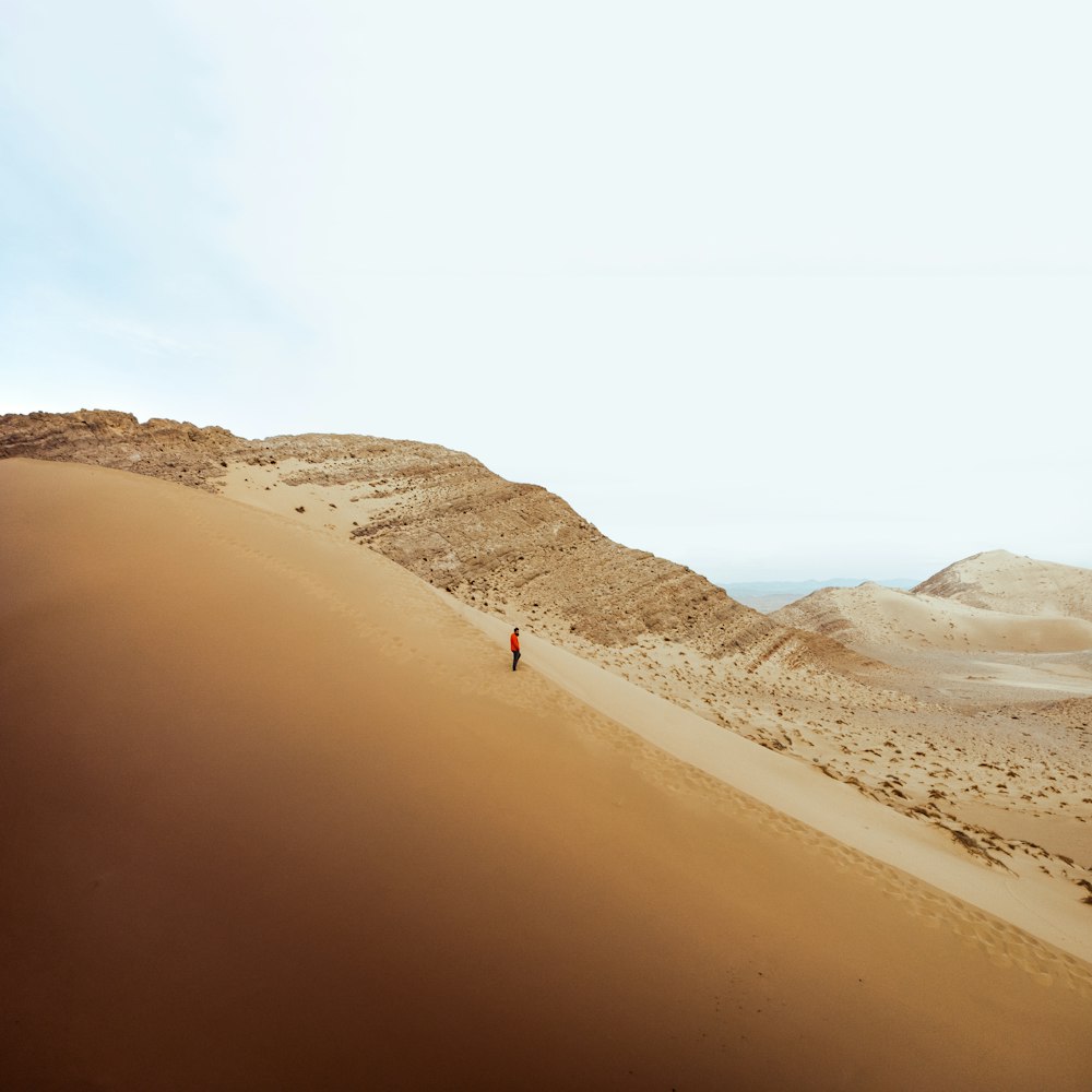 a person walking on a sandy hill