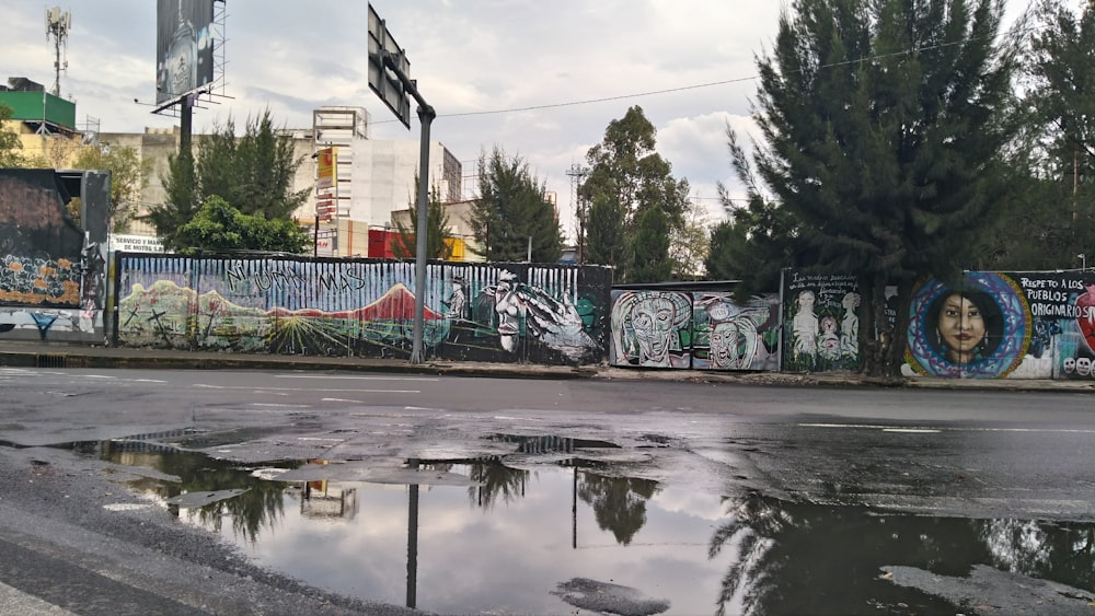 a wet street with graffiti