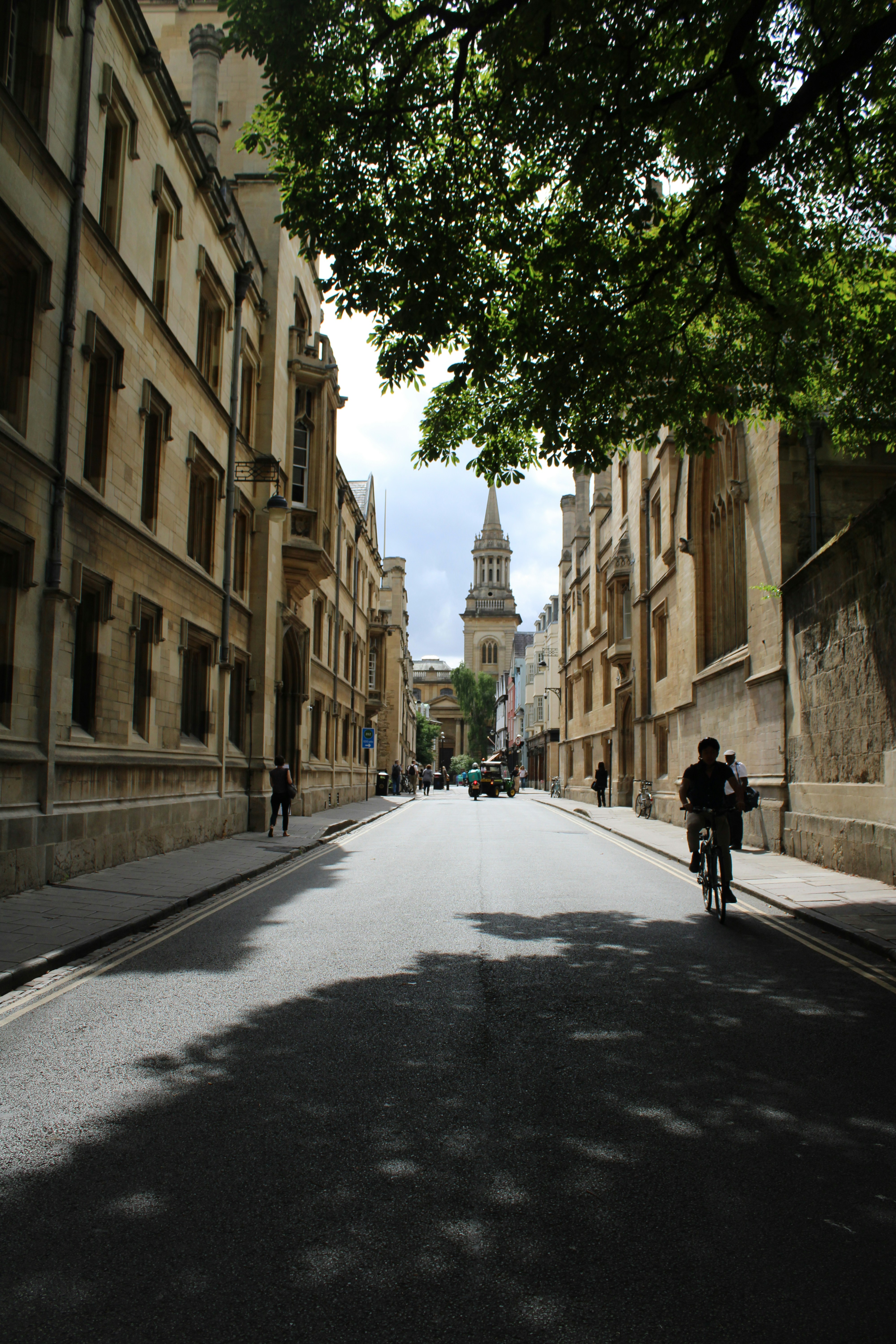 a person riding a bicycle on a street between buildings