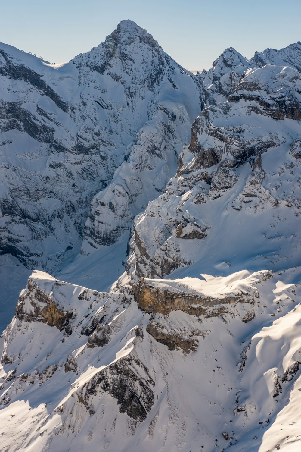 a snowy mountain with a valley below