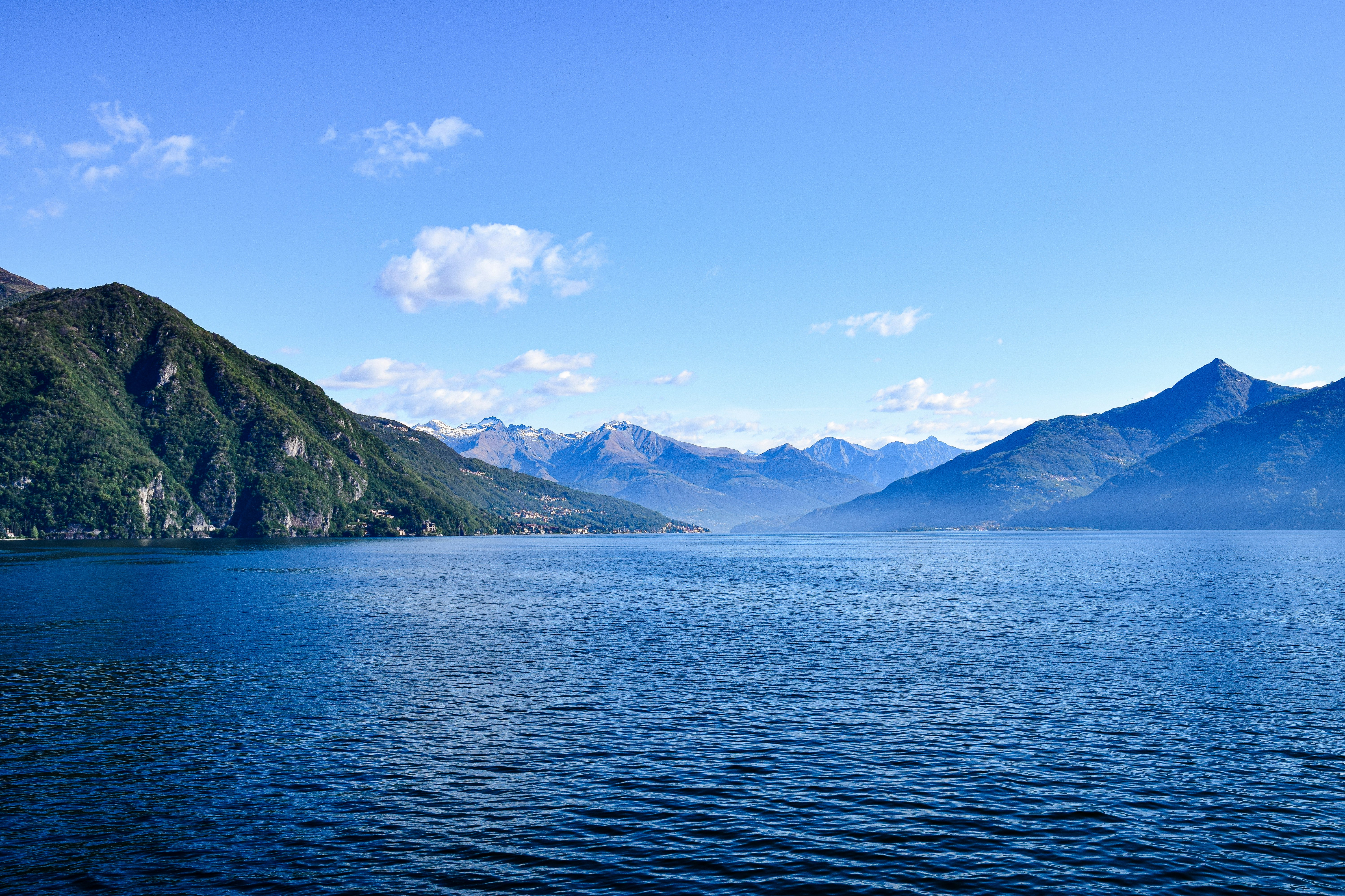 a body of water with mountains in the background, Lago de Como, Italy.
