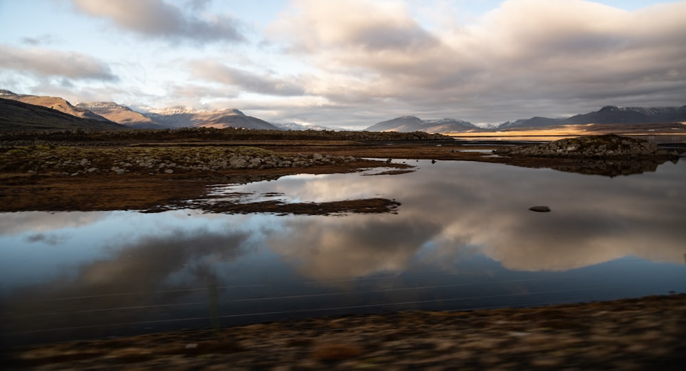 a body of water with mountains in the background