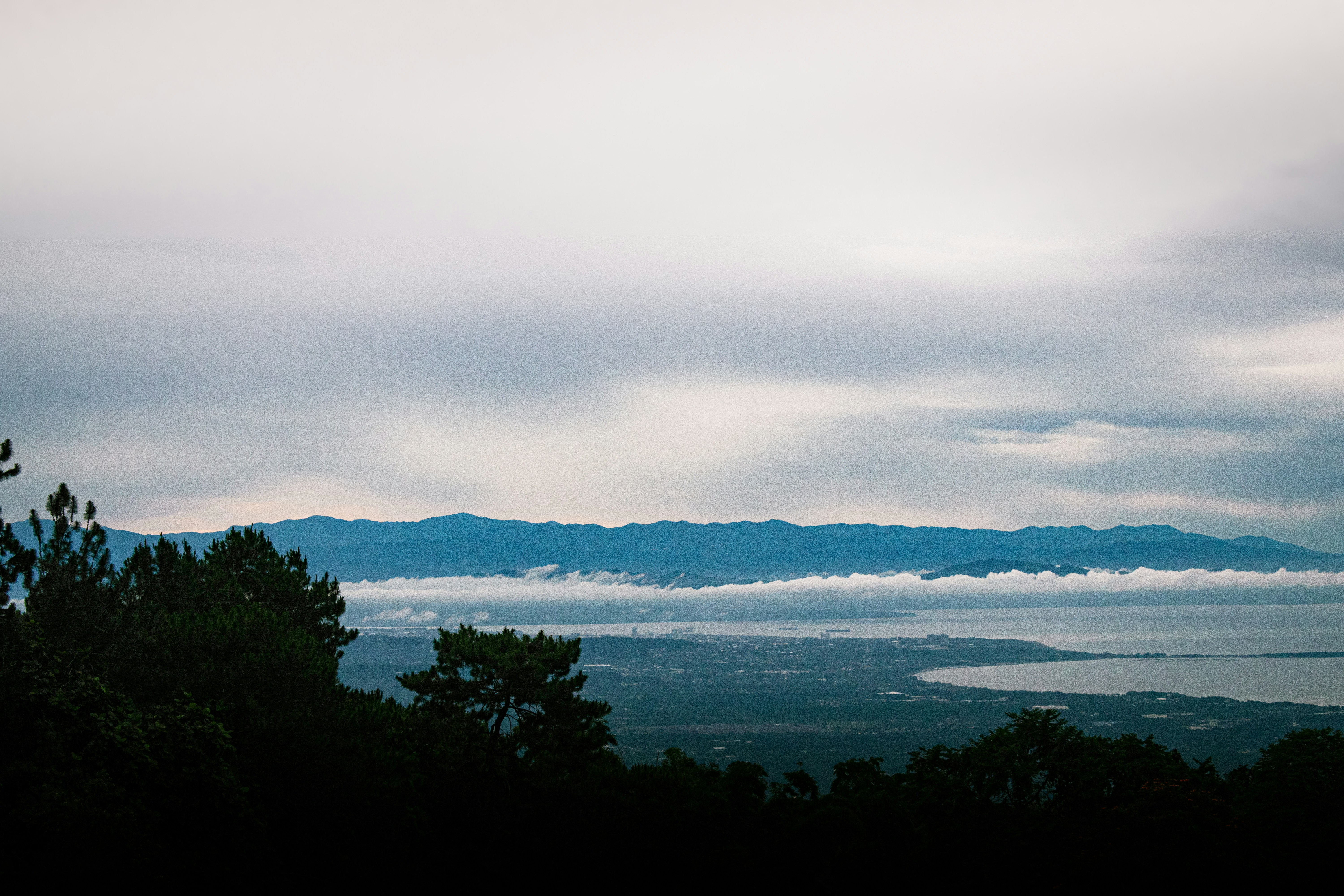 uma vista de uma cidade e do oceano de uma colina