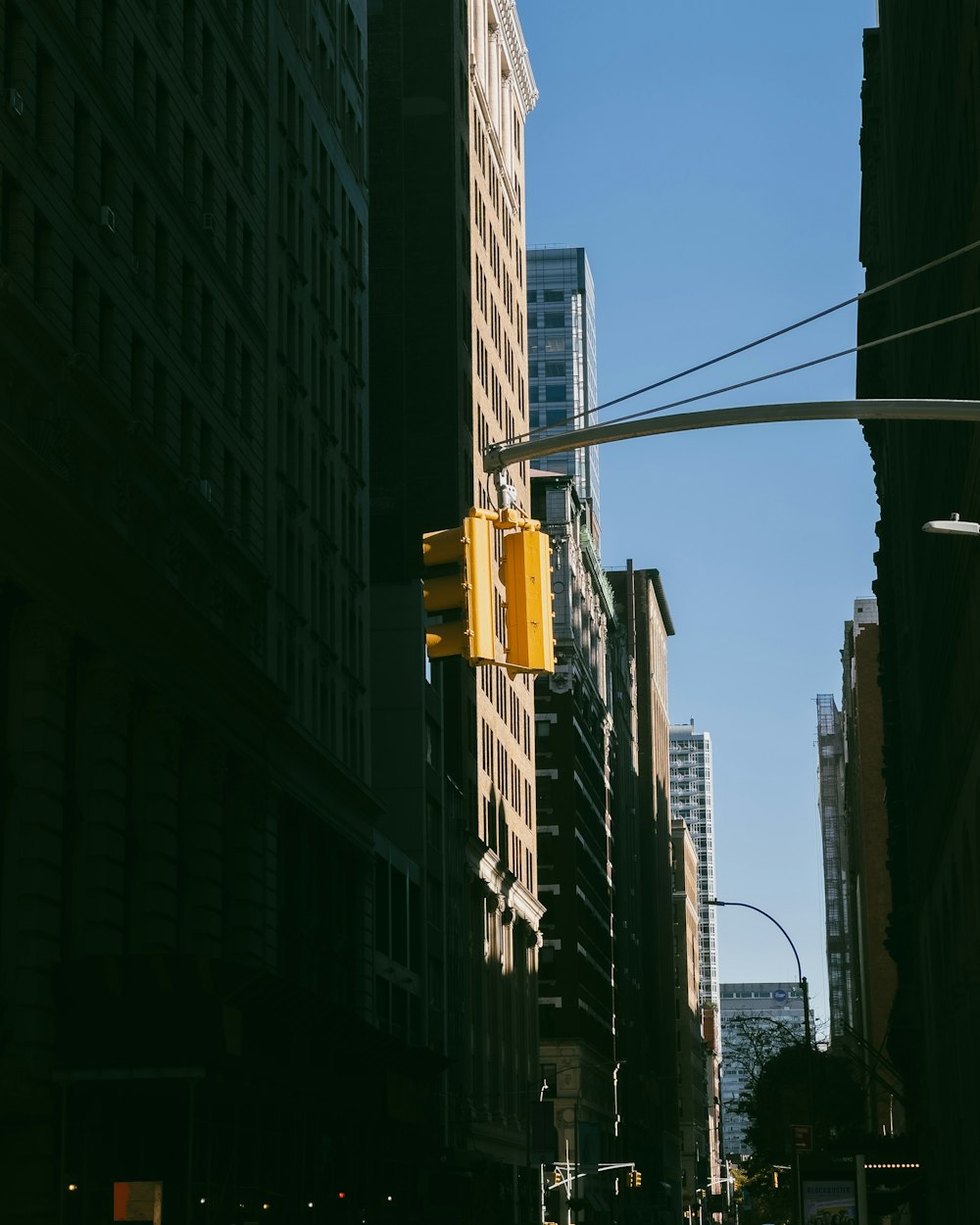 a yellow traffic light hangs from a pole