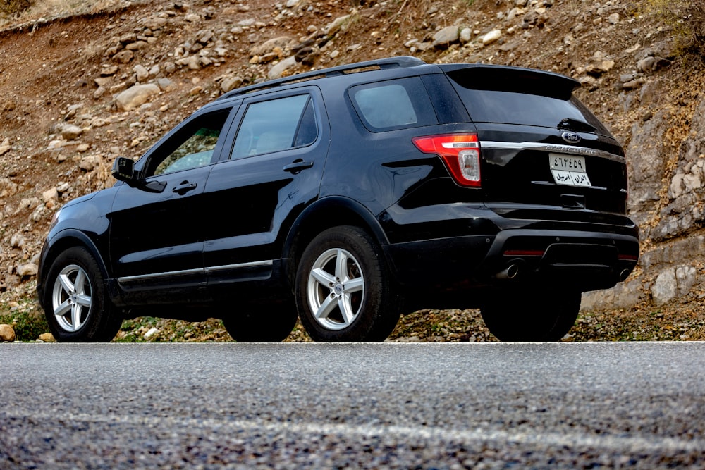 a black car parked on a rocky surface