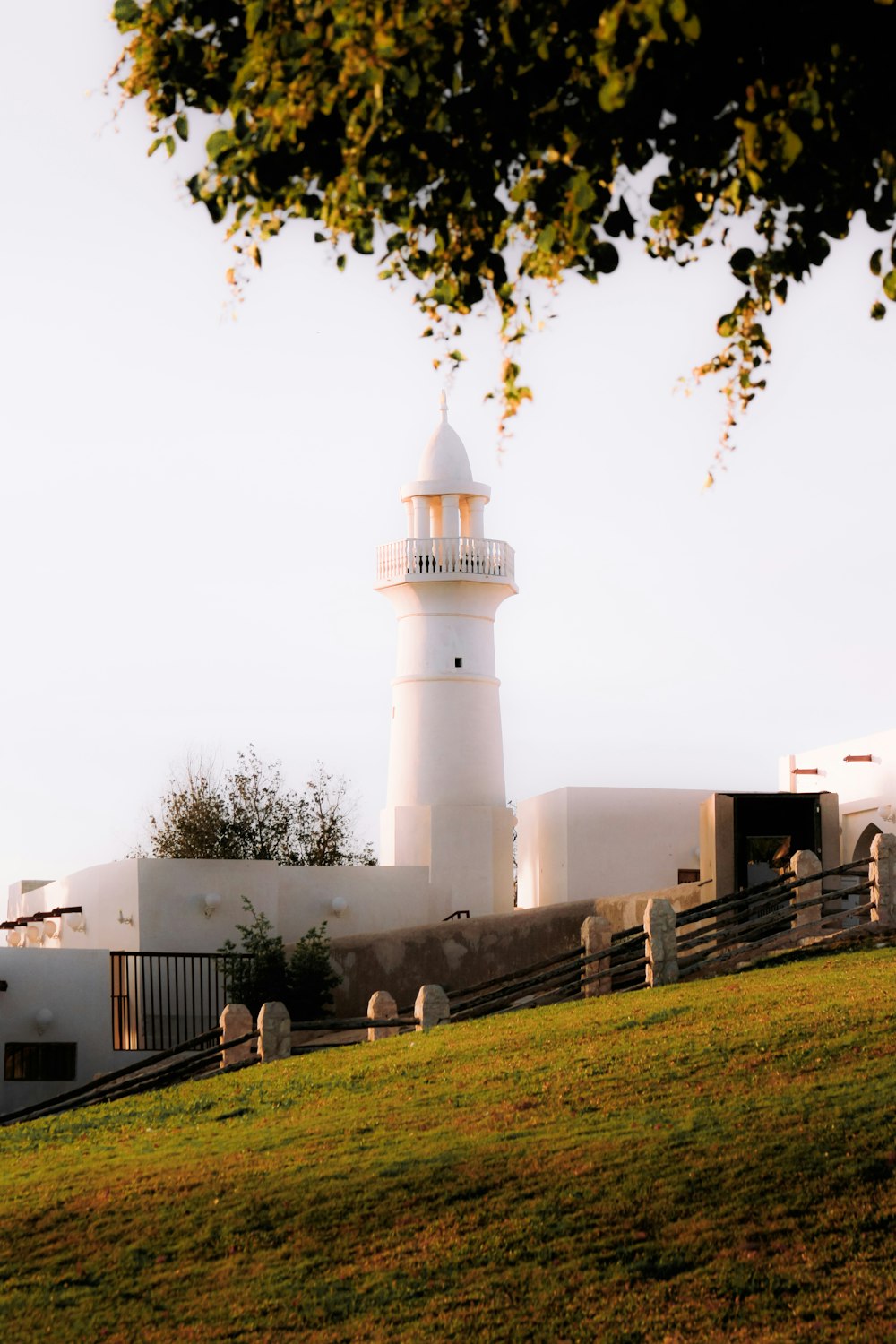 a white lighthouse with a fence around it