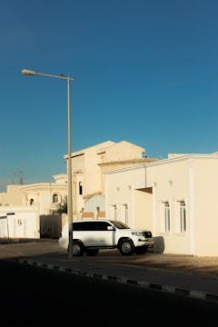 a white car parked in front of a white building