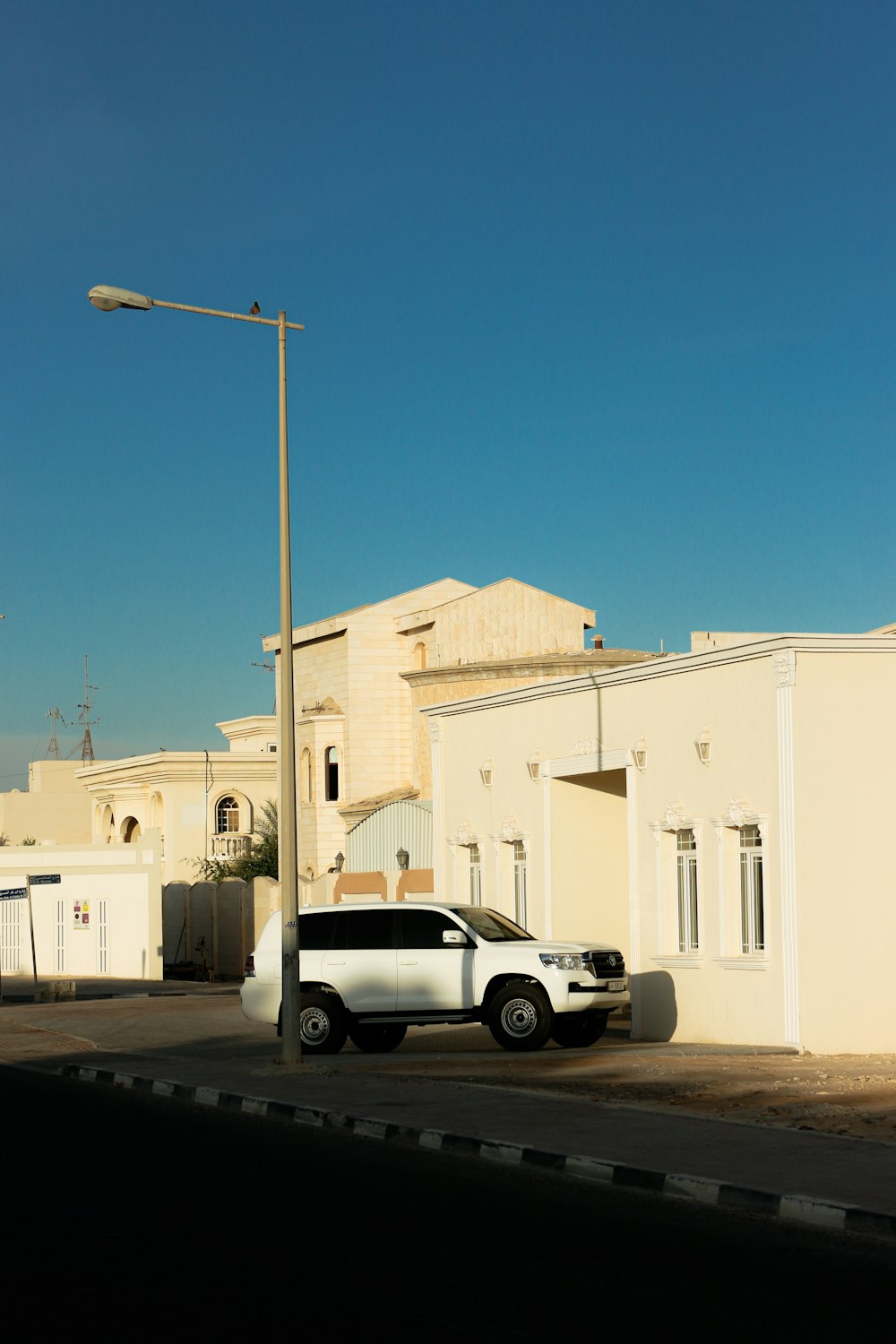 a white car parked in front of a white building