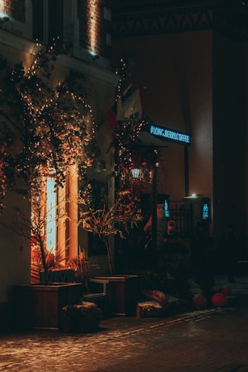Cozy nighttime storefront of a 24-hour beverage shop with warm lights and inviting entrance.