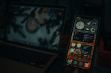 a cell phone next to a laptop