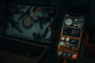 a cell phone next to a laptop