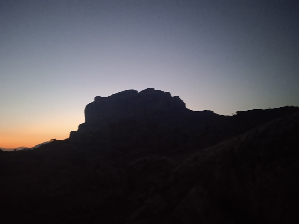 a mountain with a sunset in the background