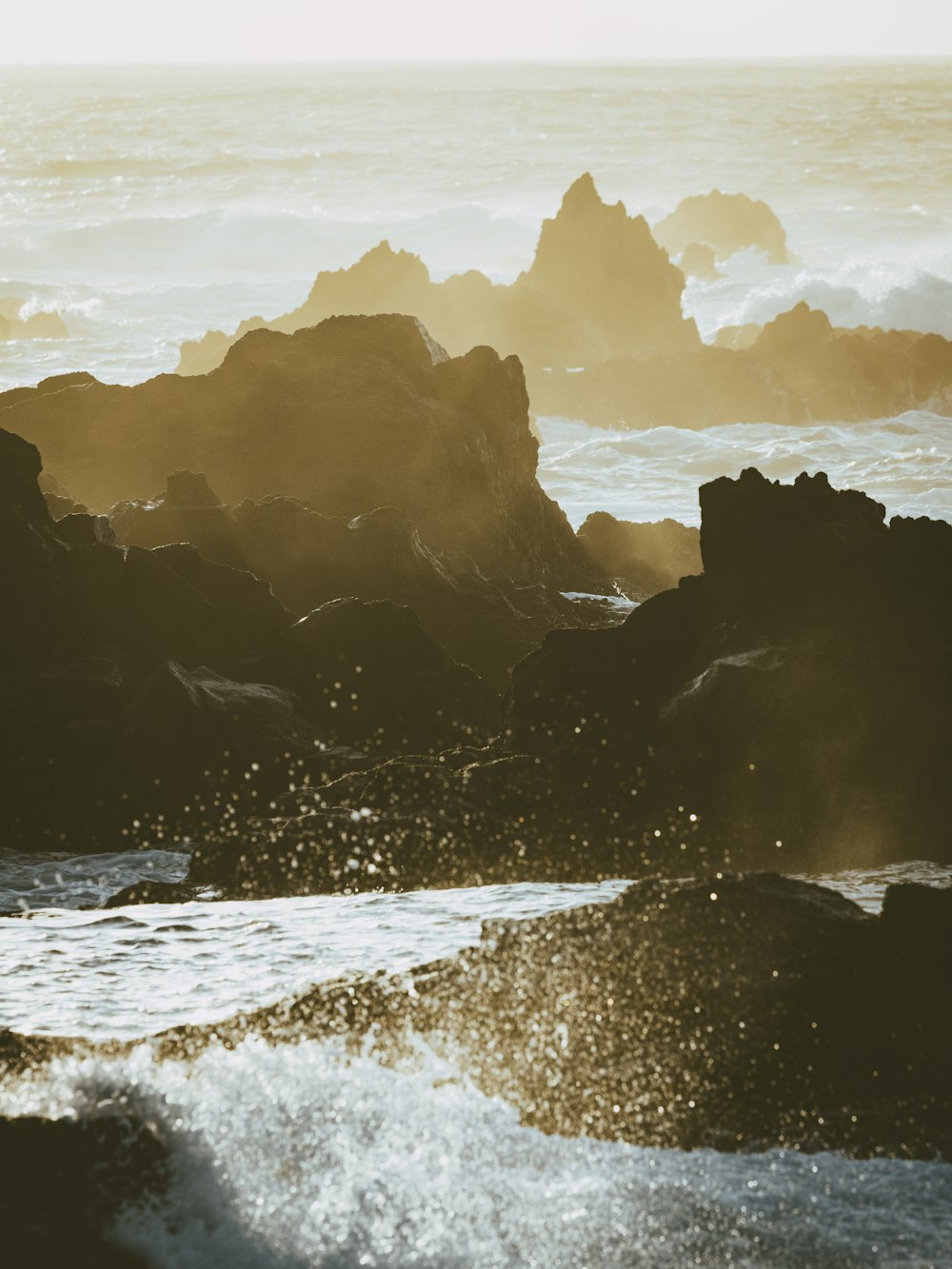 uma praia rochosa com ondas batendo contra ela