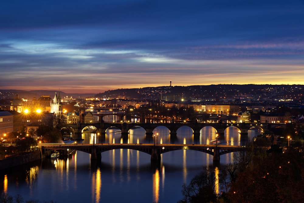 a bridge over a river with a city in the background