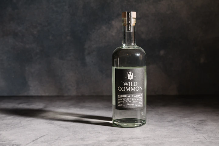 Amber-glass spirit bottle photographed on a dark ground