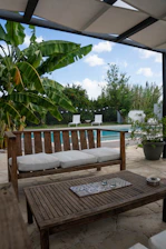 Cozy backyard scene featuring a waterproof wicker bench and teak coffee table under soft sunlight.