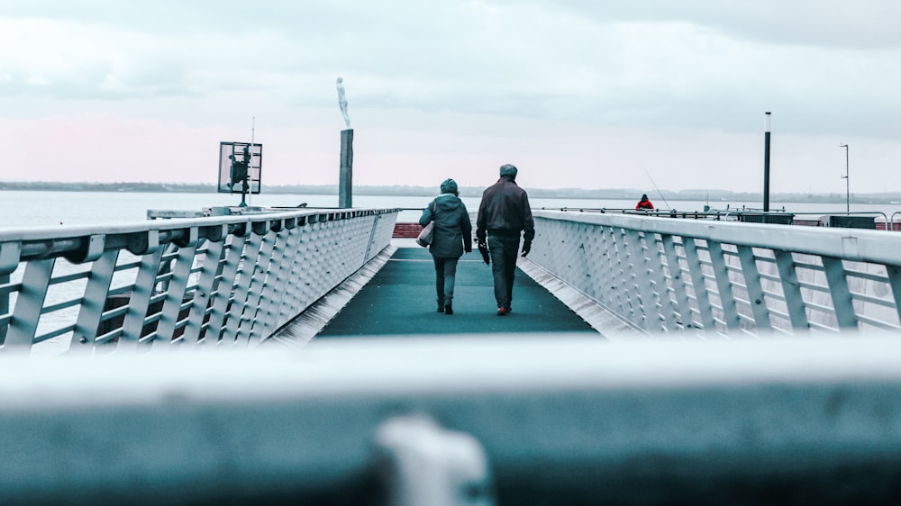 a man and woman walking on a bridge