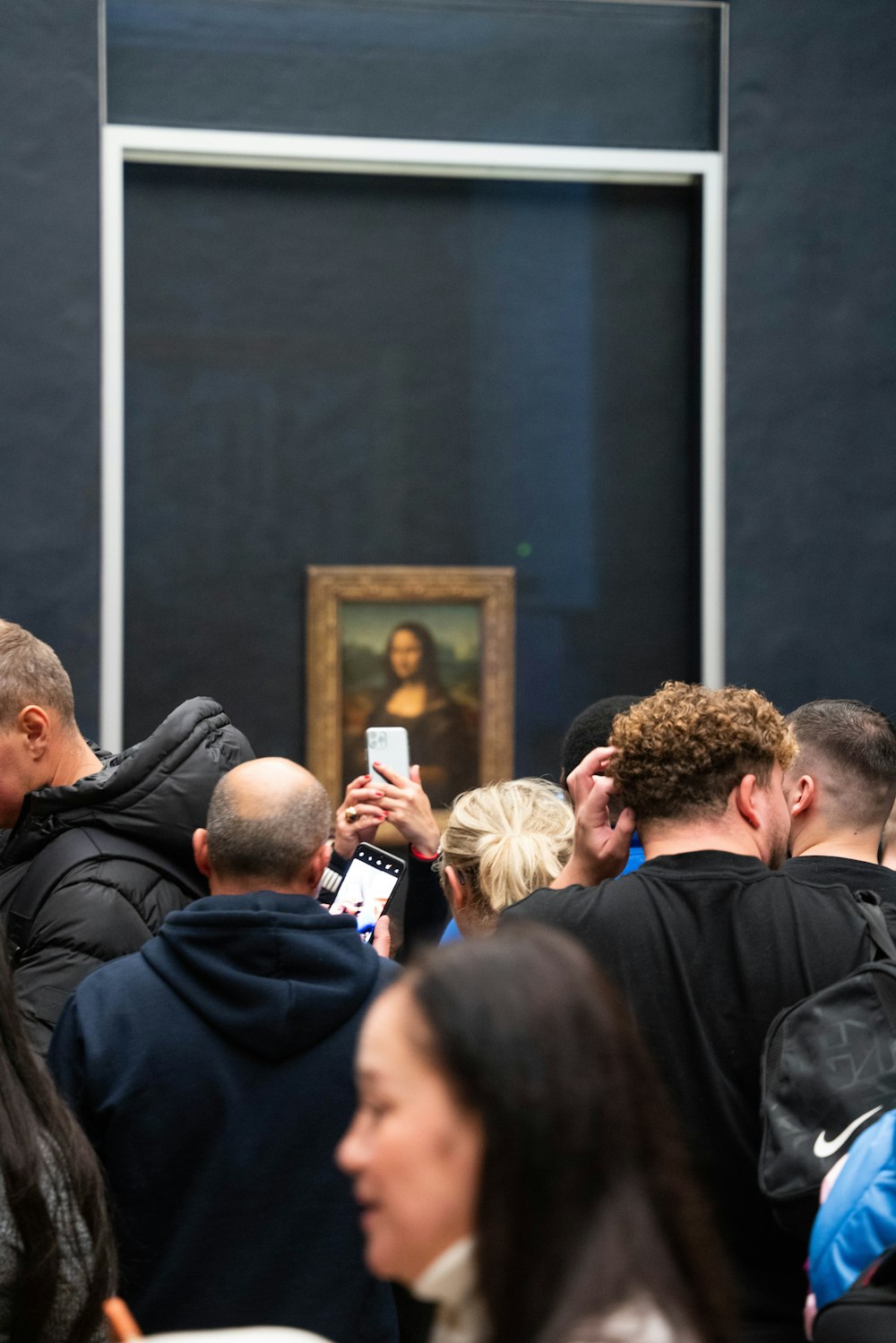 Un grupo de personas mirando una pintura en una pared