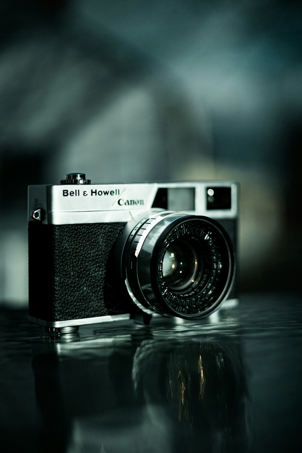 a black and white photo of a camera on a reflective surface