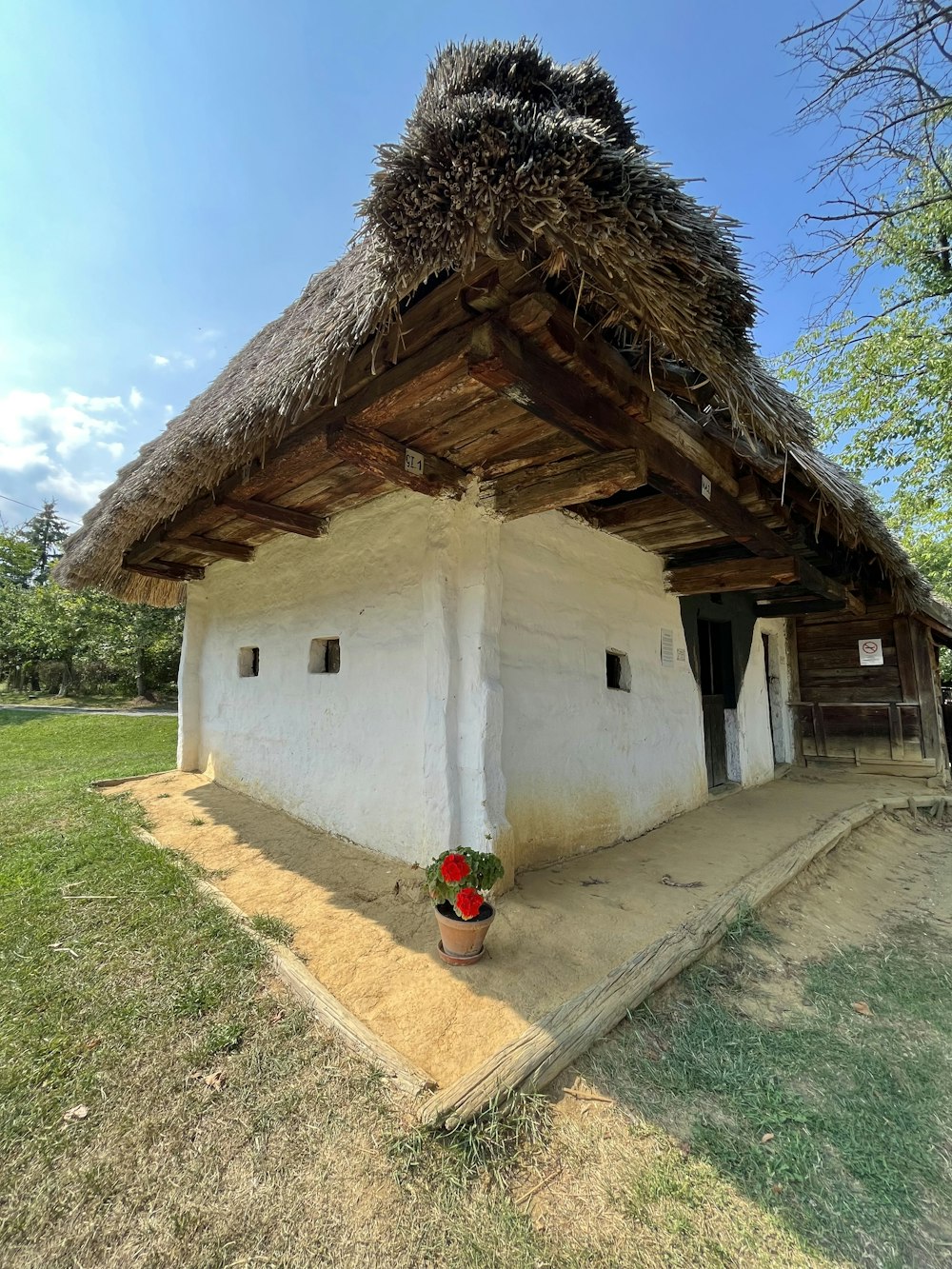 a small white building with a grass roof