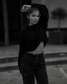A model wearing a dark brown sweater in a park during fall.