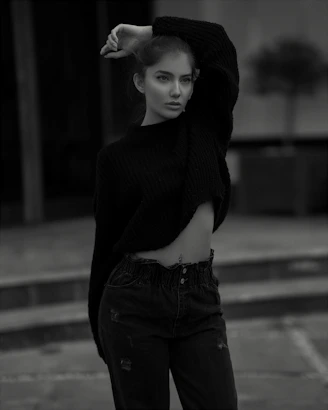 Model wearing a neutral-toned oversized sweatshirt against an urban street backdrop.