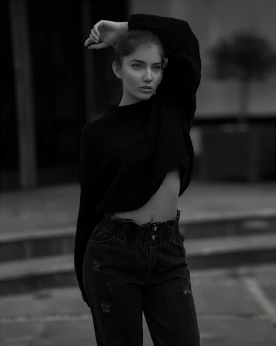 Model wearing a neutral-toned oversized sweatshirt against an urban street backdrop.