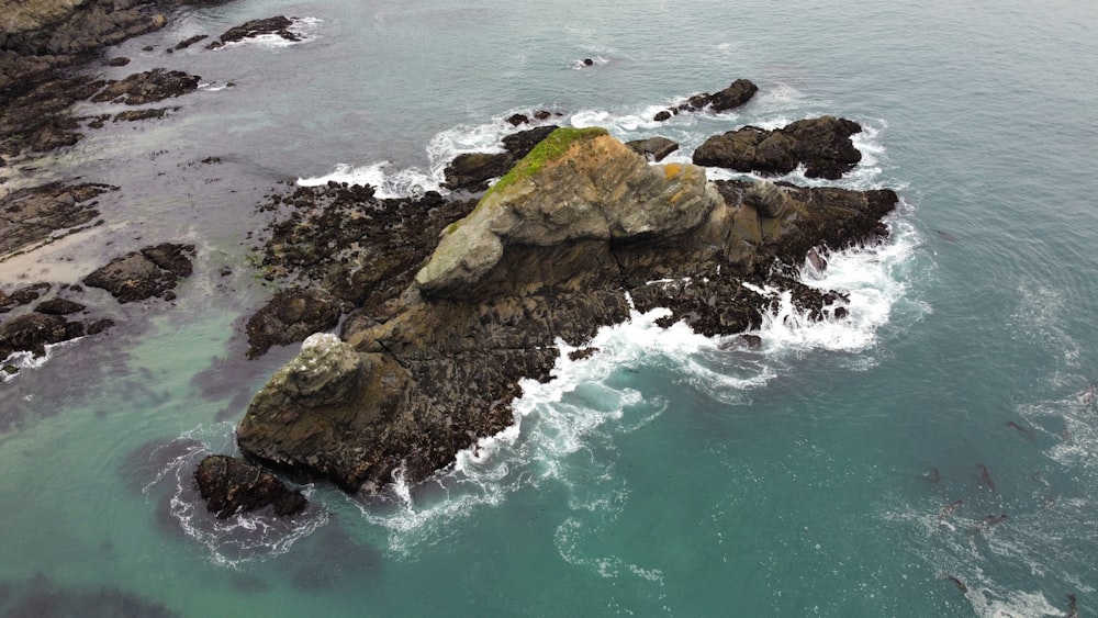 a rocky beach with a body of water in the background