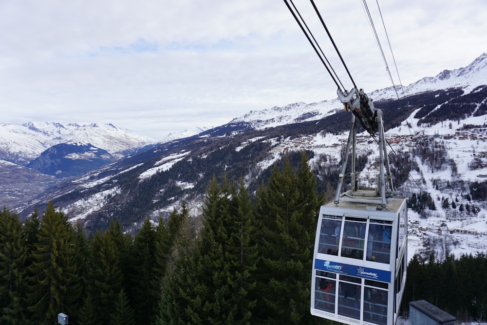 a cable car above trees and mountains