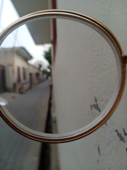 Close-up of an expert examining a painting with a magnifying glass in a bright, modern studio.