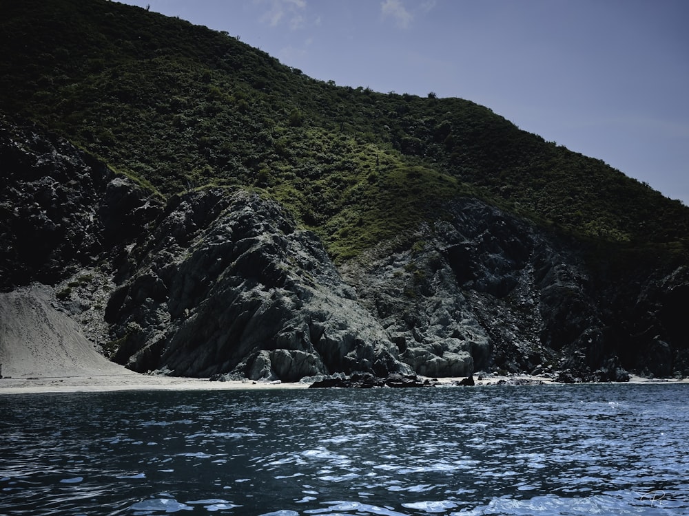 a rocky cliff next to a body of water