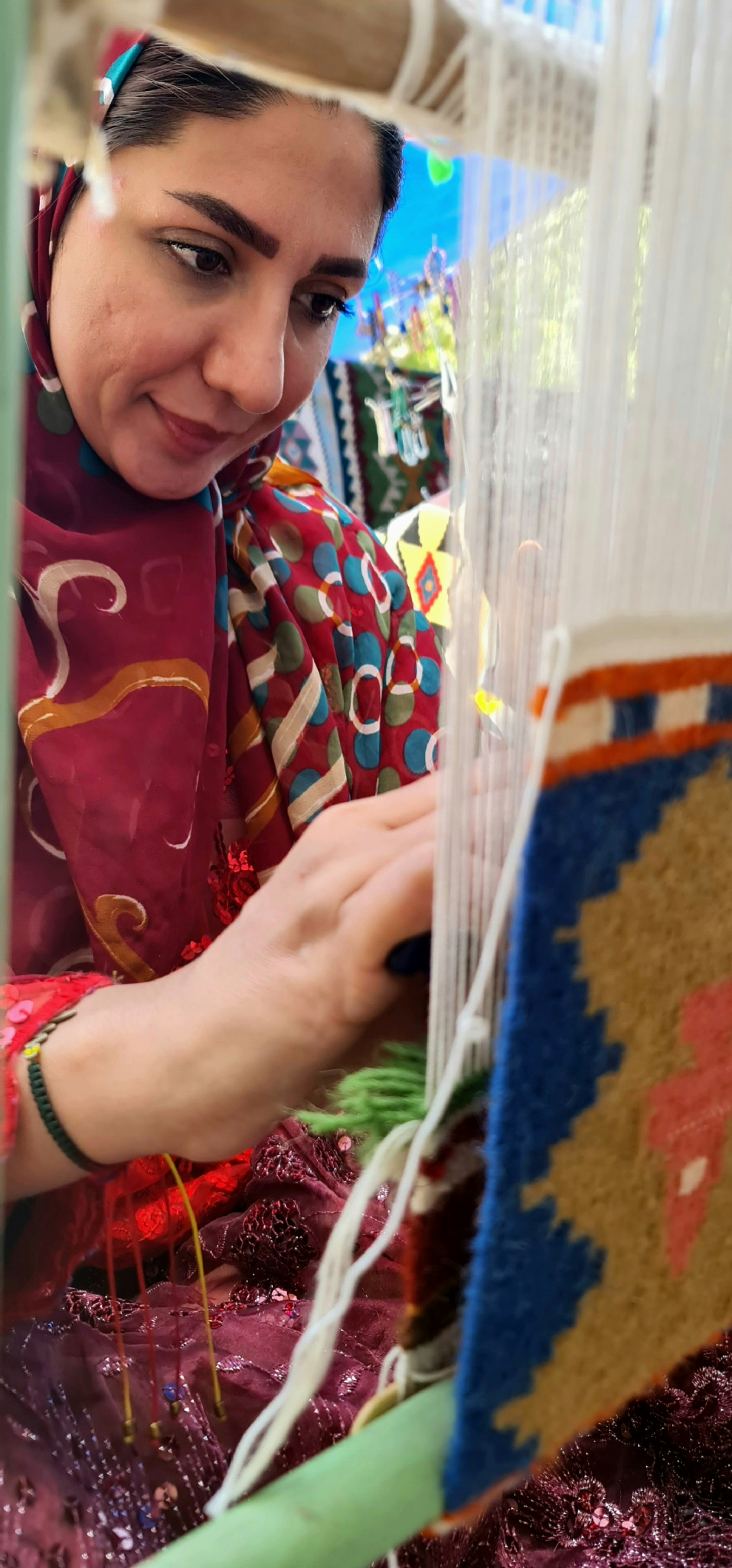 Close-up of a skilled artisan weaving a vibrant dupatta on a traditional loom.
