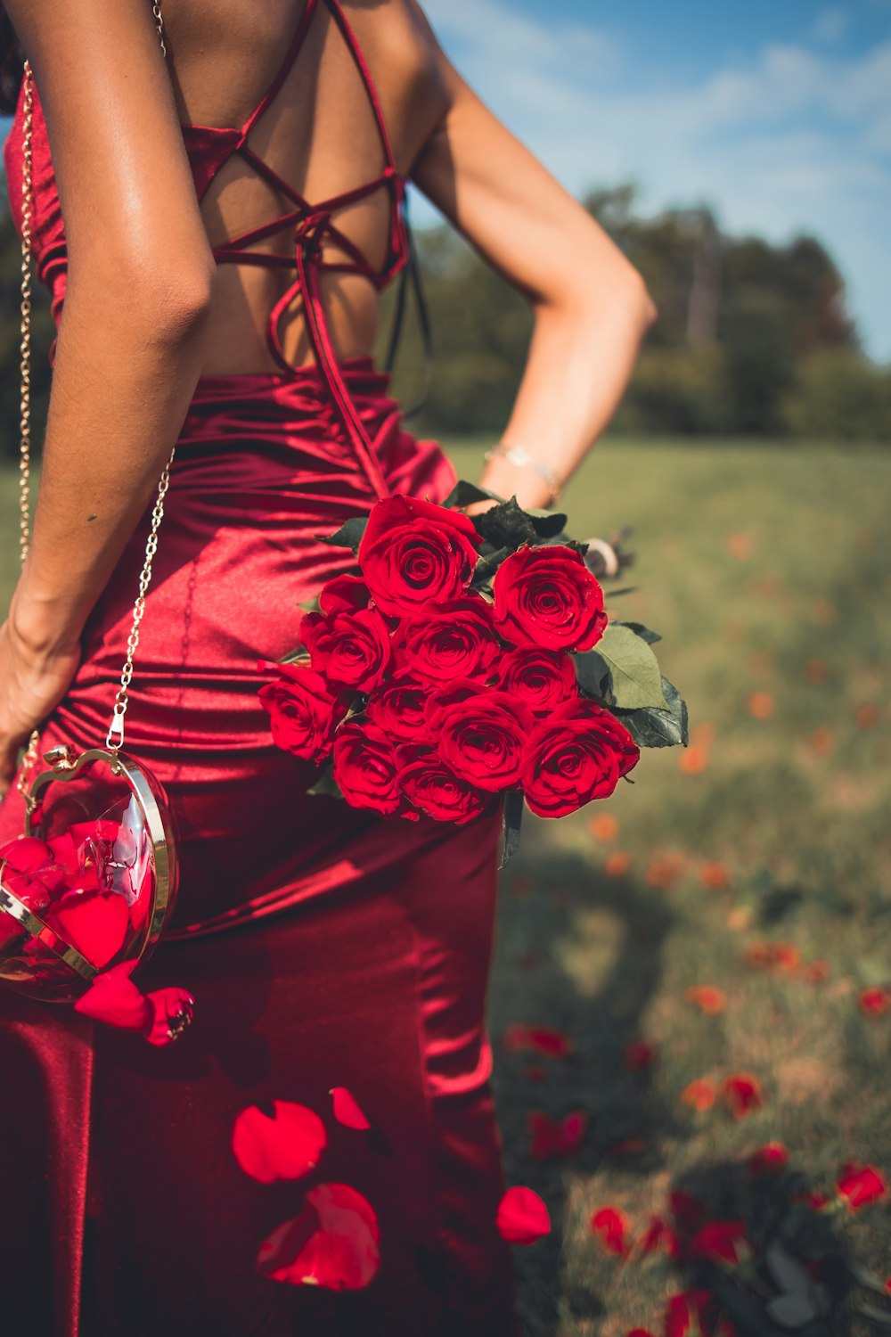 a woman holding a bouquet of red roses