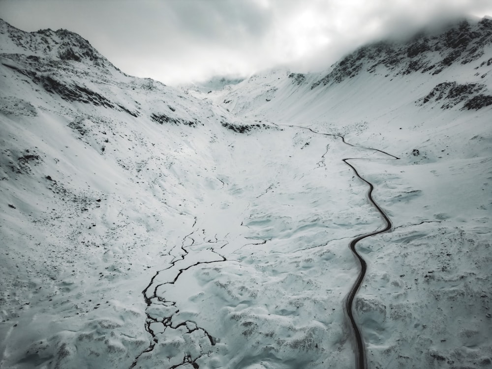 a snowy mountain with a trail