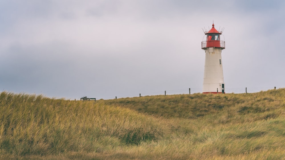 a lighthouse on a grassy hill