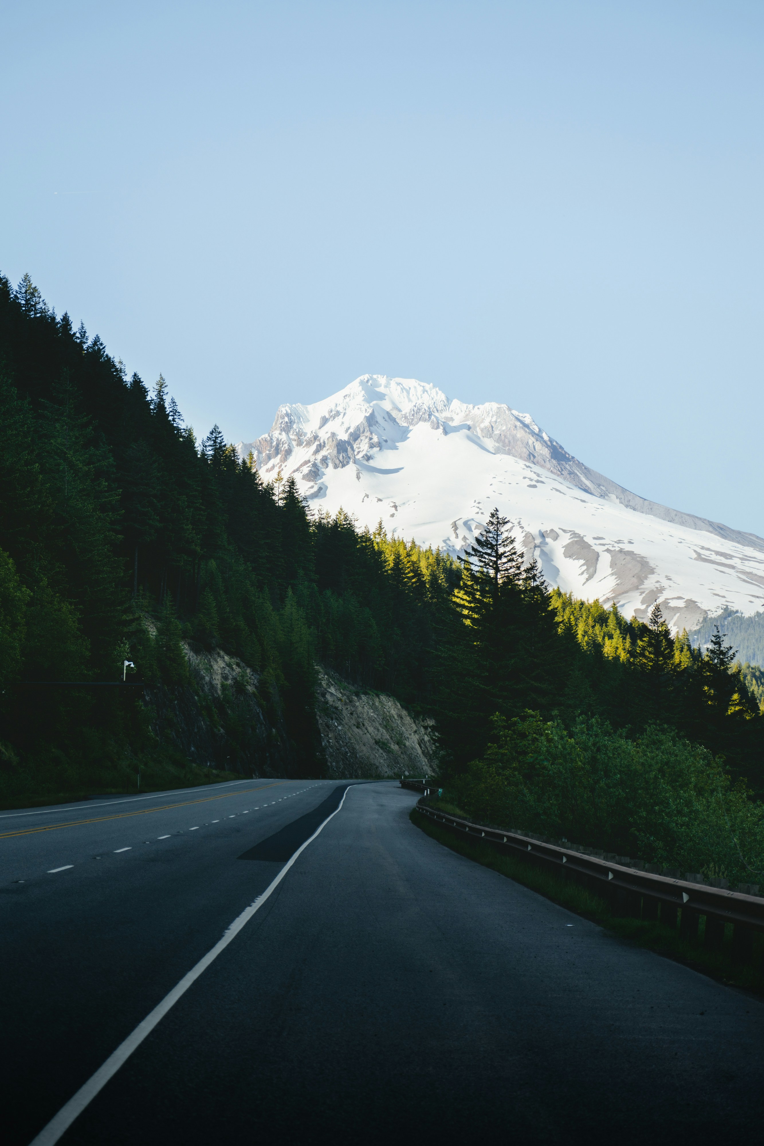 a road with trees and mountains in the background