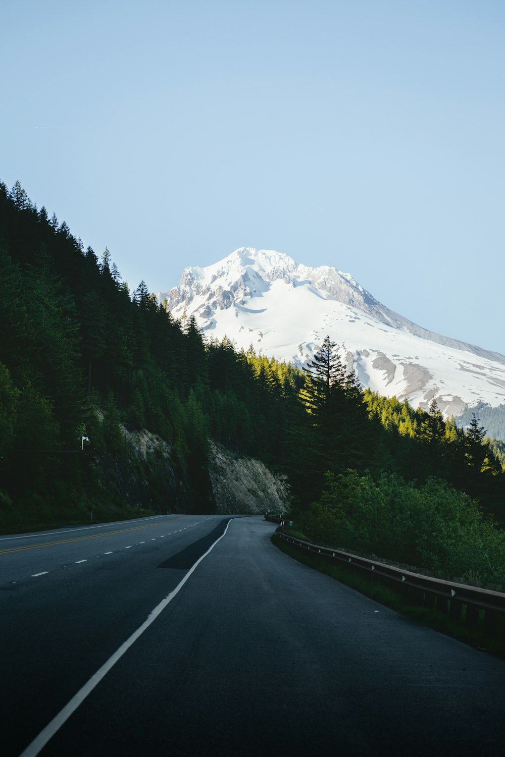 a road with trees and mountains in the background