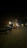 Motorcycle with bright LED headlights shining on a dark road at night.