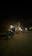 Motorcycle with bright LED headlights shining on a dark road at night.