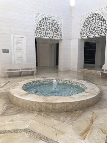 A peaceful courtyard with arches and fountains in a traditional Islamic school.