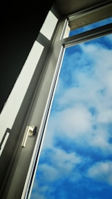 Close-up of skilled hands framing a window opening on a sunny day.