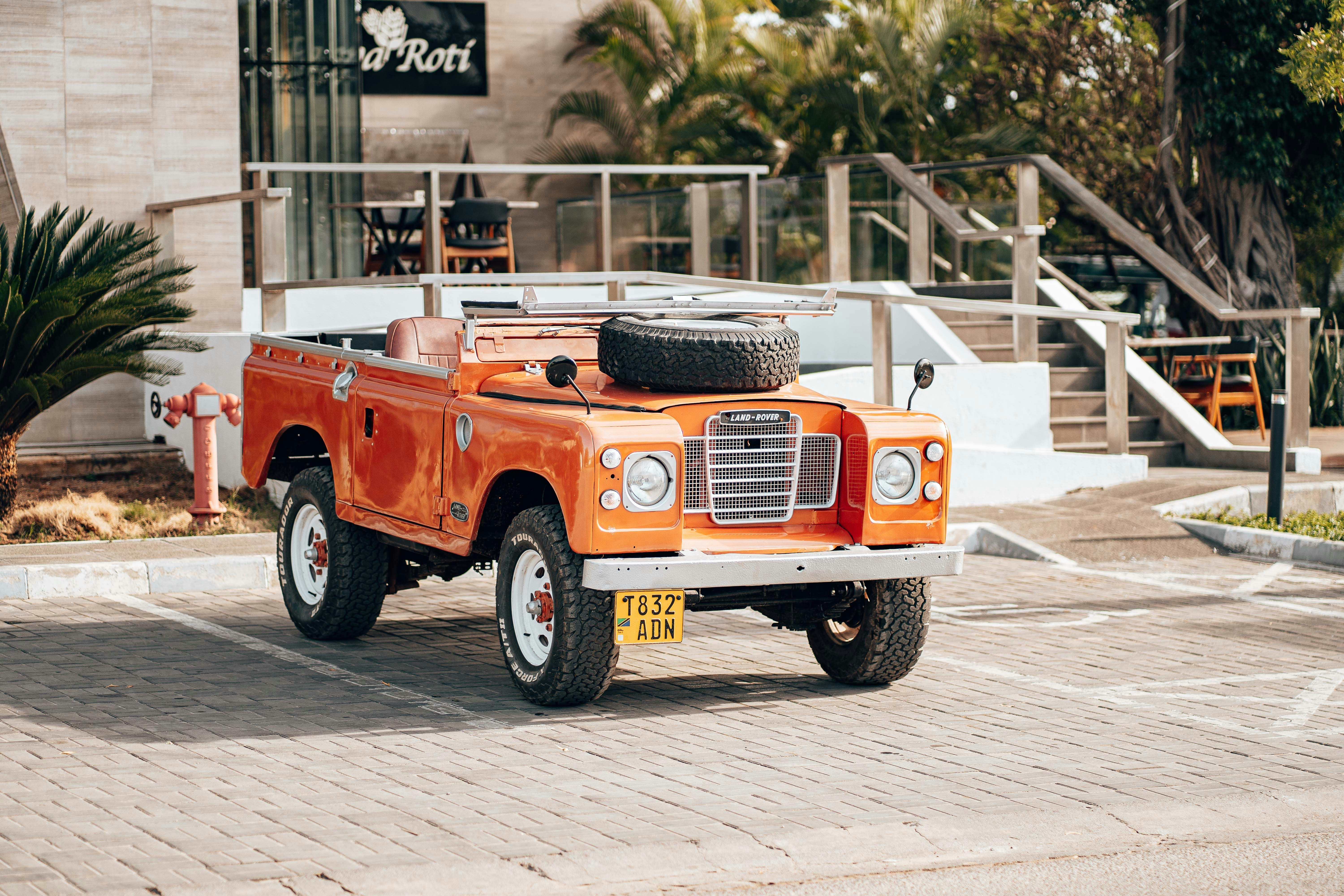 an orange truck with a couple of tires on the back