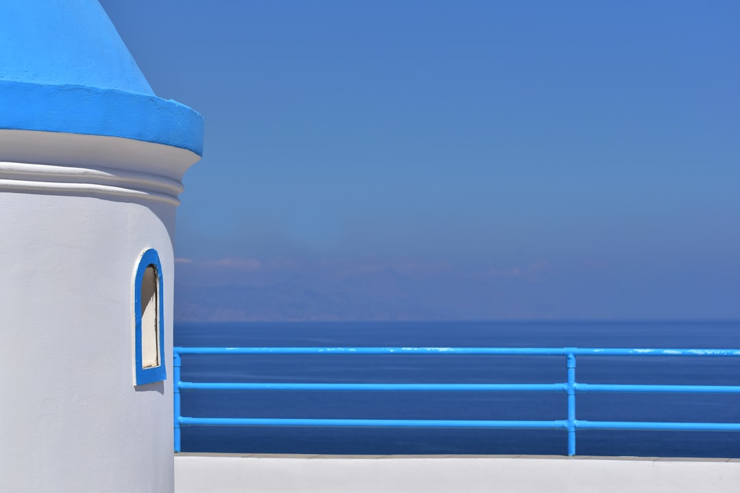 a white building with a blue sky, `The mountains are in the distance` (Light mist and blue aesthetics)