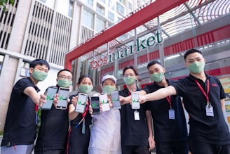 A group of volunteers wearing 'Barre Moves Forward' shirts handing out flyers at a local farmers market.
