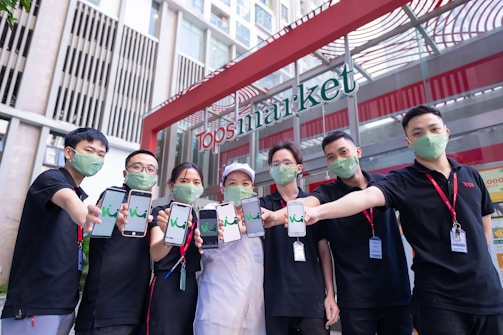 A group of volunteers wearing 'Barre Moves Forward' shirts handing out flyers at a local farmers market.