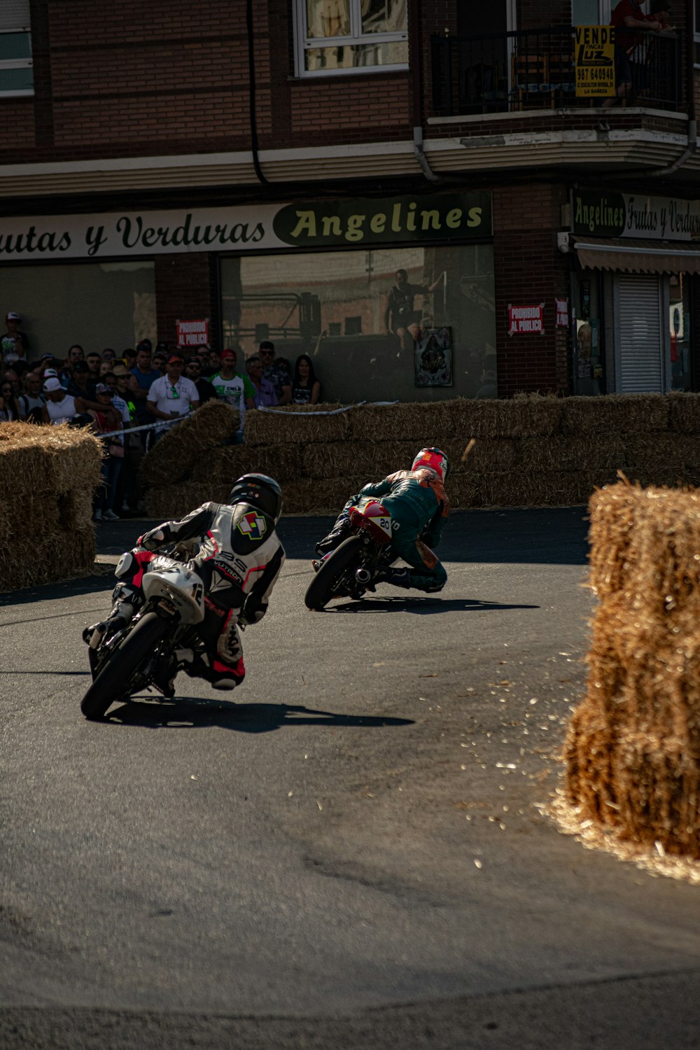 a couple of motorcyclists racing down a street