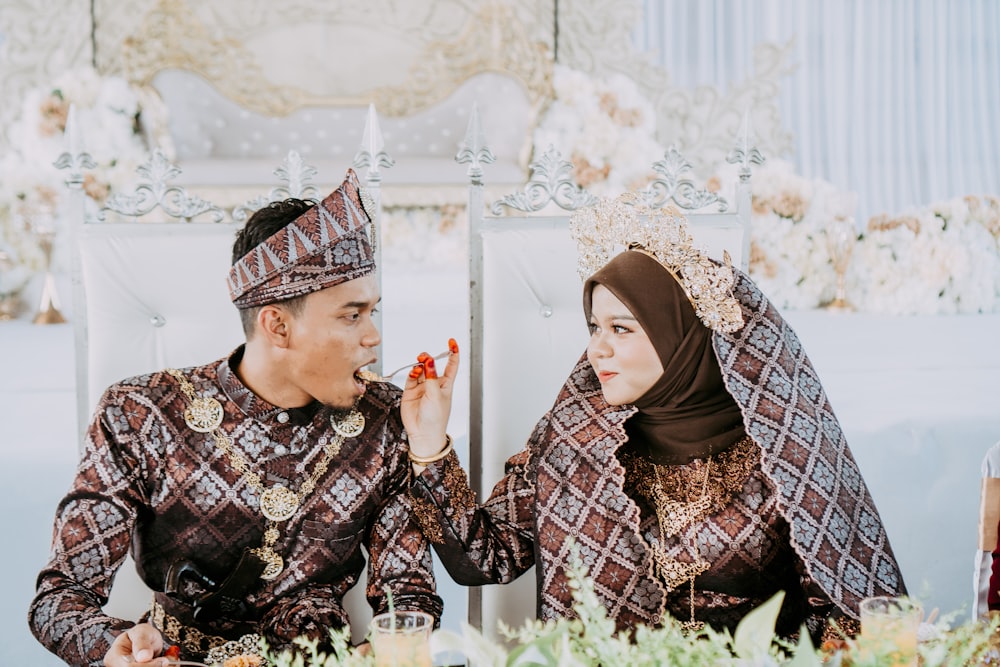 a man and woman sitting on the ground