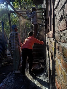 Construction workers laying bricks on a sunny day, showcasing craftsmanship and teamwork.