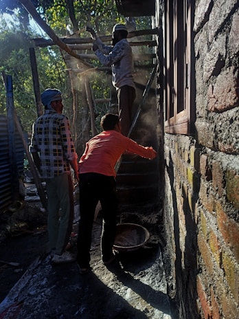 Construction workers collaborating on a masonry project at a sunny site.