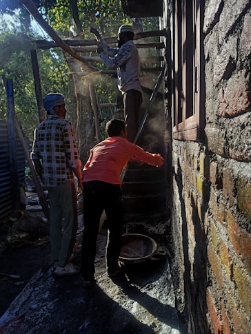 Team of plaster specialists discussing project plans on a construction site.